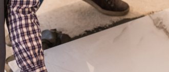 мастер по укладке плитки за работой